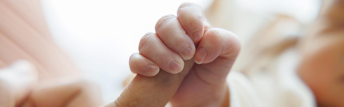 Premature/pre-term baby hand holds mum's index finger